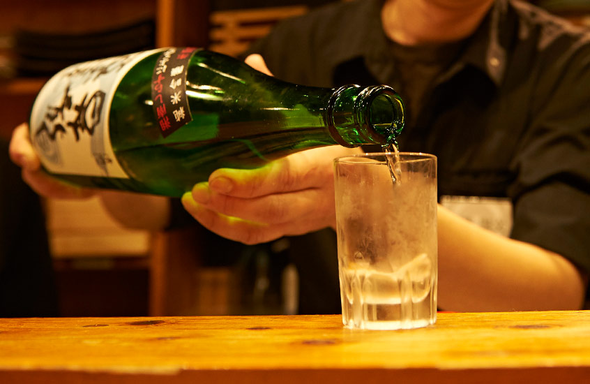 日本酒注いでいる手元